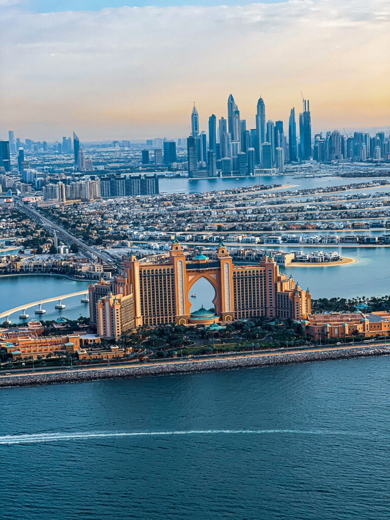 Aerial shot capturing Close-up of a Falcon Heli Tours chopper mid-air above the Arabian Gulf and city skyline Burj Al Arab and surrounding beaches from a helicopter window